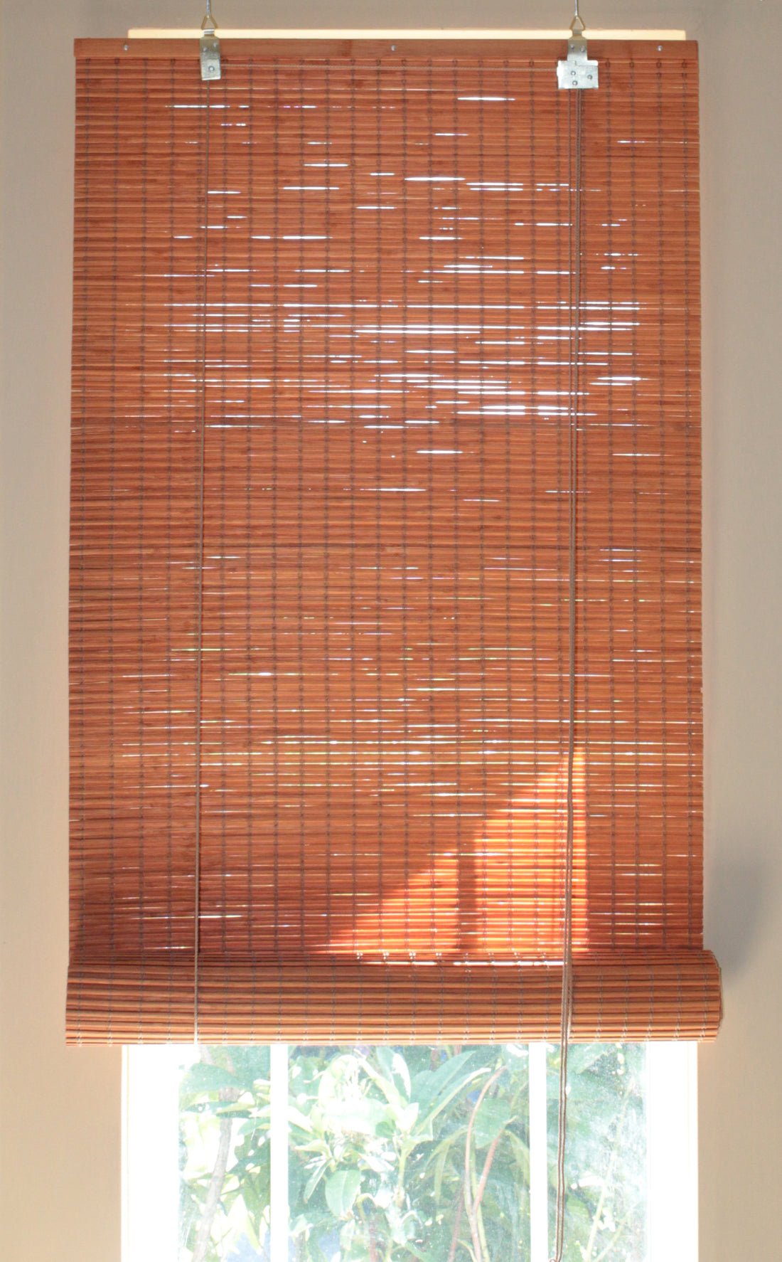 Natural real bamboo roll up blind with bamboo slats slightly overlapping each other to minimize the gap between slats